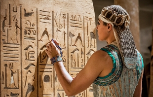 Ilustração de um escriba egípcio fazendo heiróglifos numa parede