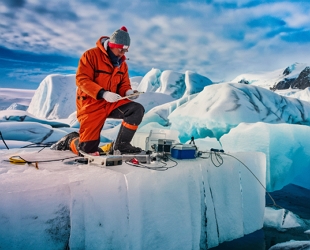 Imagem de um glaciologista fazendo estudos numa região coberta por gelo