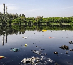 Foto de um rio com água poluída e suja