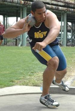 Atleta fazendo o arremesso de peso do Atletismo