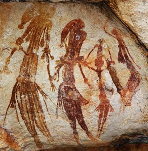 Pintura vermelha na parede de uma caverna representando quatro pessoas