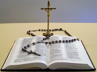 Foto de uma B&iacute;blia, um ros&aacute;rio e um crucifixo