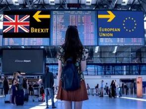 Imagem de uma mulher olhando para uma placa indicando o Brexit