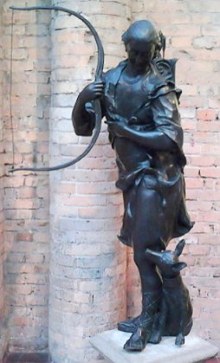 Escultura de um caçador com seu arco e flexa e um cachorro aos seus pés