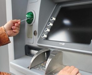 Pessoa fazendo uma operação num caixa eletrônico de banco