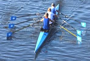 Três remadores numa canoa praticando a canoagem