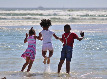 Menina pulando ondas na praia