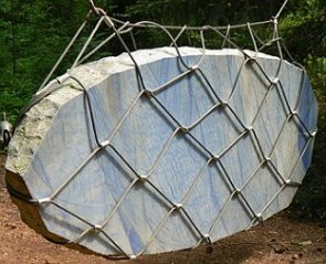 Escultura de uma pedra suspensa numa rede