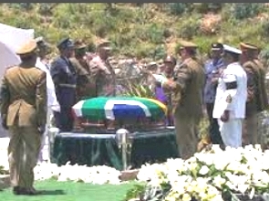 Foto mostrando militares em volta de um caixão coberto com a bandeira da África do Sul
