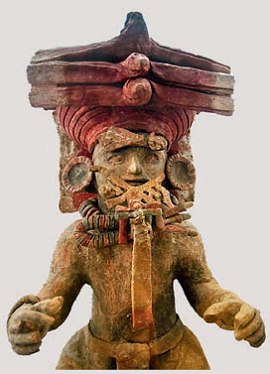Foto de uma escultura maia representando uma pessoa usando uma esp&eacute;cie de chap&eacute;u