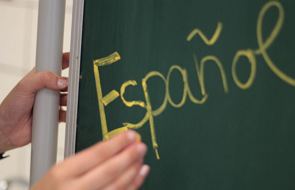 Lousa e uma m&atilde;o com a palavra escrita Espa&ntilde;ol
