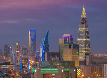 Foto noturna da cidade de Riad mostrando pr&eacute;dios modernos iluminados