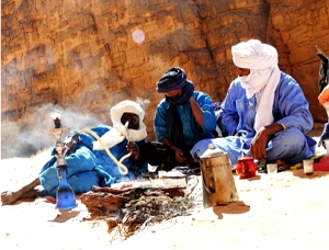 Foto de tuaregues sentados numa regi&atilde;o de deserto