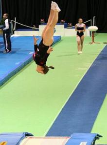 Ginasta fazenda uma acrobacia na Gin&aacute;stica de Trampolim