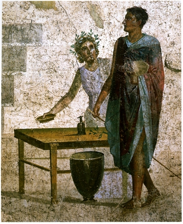 Desenho em parede mostrando um homem vestindo uma t&uacute;nica e uma mulher, ambos pr&oacute;ximos a uma mesa.