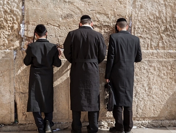 Tr&ecirc;s judeus orando no muro das lamenta&ccedil;&otilde;es em Jerusal&eacute;m