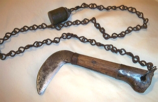 Foto de uma arma ninja com corrente e esp&eacute;cie de foice na ponta.