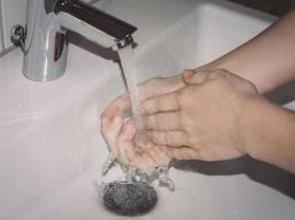 Pessoa lavando as mãos numa pia