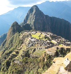 Foto da região montanhosa de Machu Picchu mostrando ruínas da cidade.