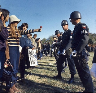 Foto mostrando uma jovem entregando uma flor para um policial em uma manifesta&ccedil;&atilde;o contra a Guerra do Vietn&atilde;, em 1967