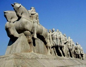 Foto de uma escultura grande representando homens em cavalos e outros andando a pé