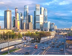 Foto de uma parte da cidade mostrando pr&eacute;dios altos e modernos e uma avenida com carros.