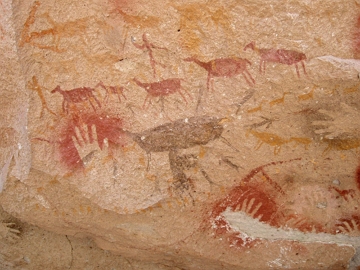 Pintura em parade de caverna mostrando animais e seres humanos