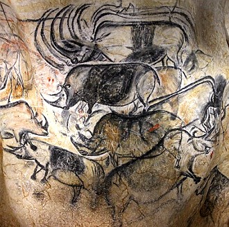 Pintura rupestre de animais como rinocerontes em parede de caverna