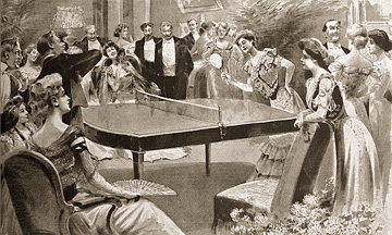 Imagem antiga mostrando mulheres jogando t&ecirc;nis de mesa num sal&atilde;o com muitas pessoas.