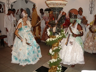 Foto de um ritual de Candombl&eacute; com mulheres usando vestidos, no destaque