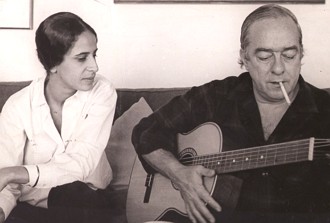 Foto de Vin&iacute;cius de Moraes tocando viol&atilde;o ao lado de Maria Bet&acirc;nia
